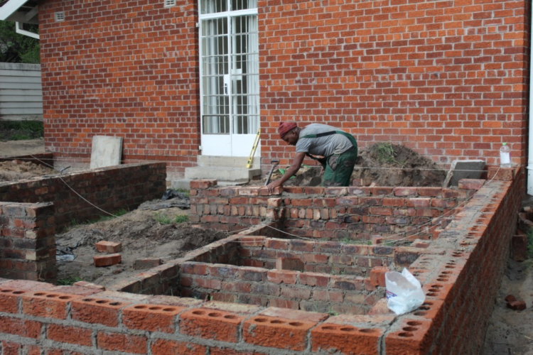 Builders on-site laying up the foundation of the extension of the female ward